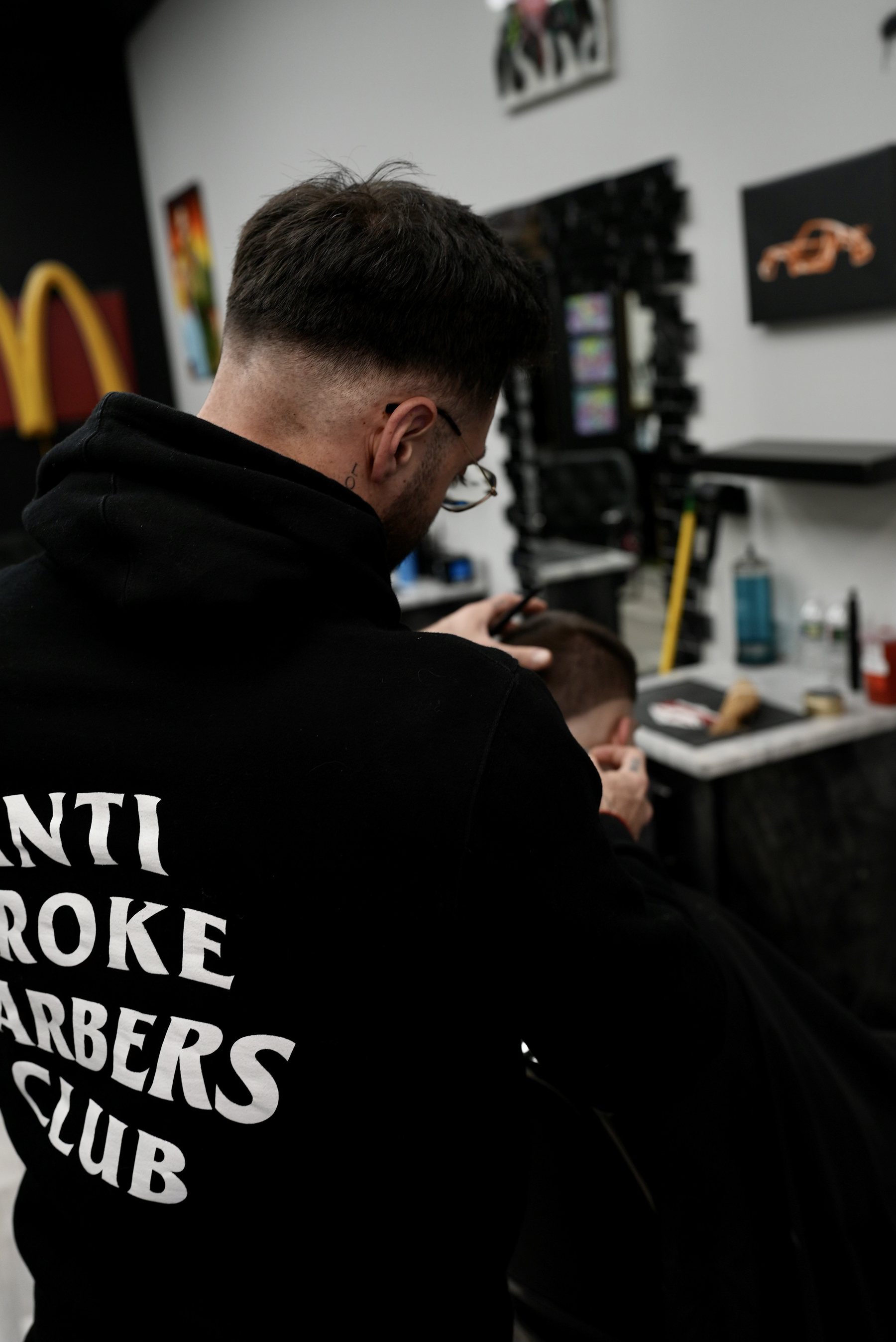 A barber lining up a cut at Tangos Barbershop